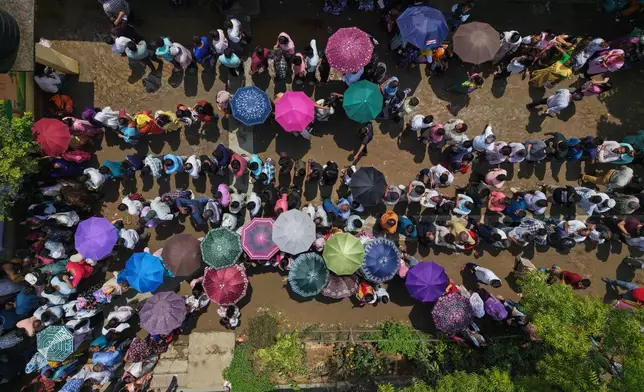 People stand in queue to cast their votes at a polling center during the state election in Guwahati, India, Thursday, April 9, 2026. (AP Photo/Anupam Nath)