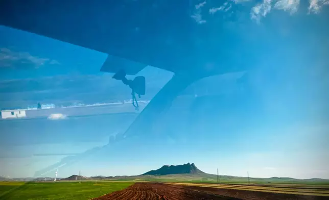 A cultivated field with a mountain range in the background, seen from a car on Road 2 between Takestan and Zanjan, Iran, Thursday, April 9, 2026. (AP Photo/Francisco Seco)