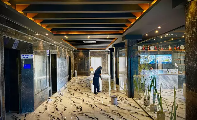 A woman cleans the floor in a roadside hotel on Road 2 near Golhahr, Iran, Thursday, April 9, 2026. (AP Photo/Francisco Seco)