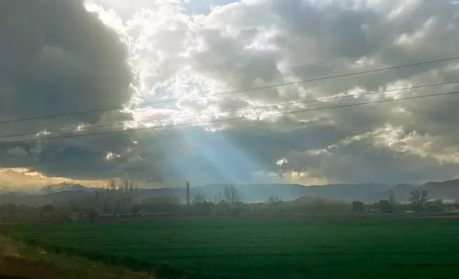Rays of sunlight break through clouds over a field on Road 11, near the Turkey border crossing, in Razi, Iran, Thursday, April 9, 2026. (AP Photo/Francisco Seco)