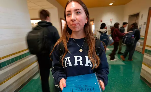 Ava Khouri, a Hanover High School senior who has trained middle school students to take initiatives to stop harmful behavior, poses in a hallway Wednesday, March 25, 2026, in Hanover, Mass. (AP Photo/Robert F. Bukaty)