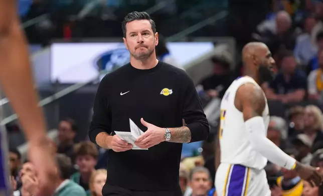 Los Angeles Lakers head coach JJ Redick walks onto the court during a time out in the first half of an NBA basketball game against the Dallas Mavericks in Dallas, Sunday, April 5, 2026. (AP Photo/LM Otero)