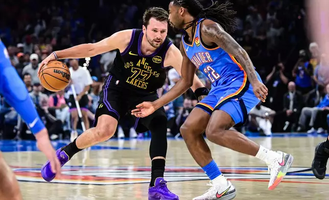 Los Angeles Lakers forward/guard Luka Dončić (77) drives against Oklahoma City Thunder guard Cason Wallace (22) during the first half of an NBA basketball game Thursday, April. 2, 2026, in Oklahoma City. (AP Photo/Gerald Leong)