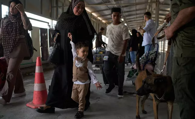 People who arrived from Iran cross the Shalamcheh border crossing between Iran and Iraq, near Basra, Iraq, Sunday, March 29, 2026. (AP Photo/Leo Correa)