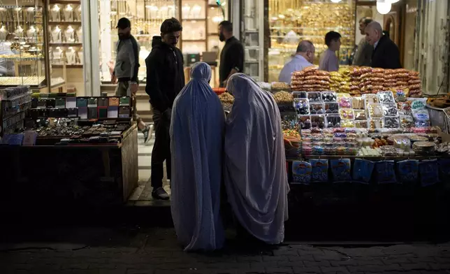 Muslim women buy goods at a market near the Kadhimiya Shrine at sunset in the Shiite neighbourhood in Baghdad, Iraq, Tuesday, March 31, 2026. (AP Photo/Leo Correa)