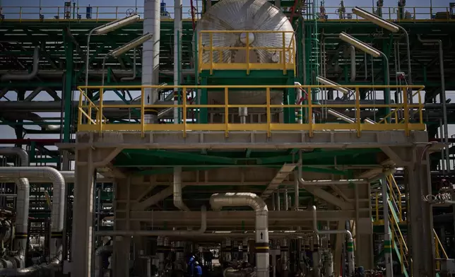 Men work on the maintenance of a pipe at a degassing station in Zubair oil field, whose operations have being reduced due to the Mideast war triggered by the U.S. and Israeli attacks on Iran, near Basra, Iraq, Saturday, March 28, 2026. (AP Photo/Leo Correa)