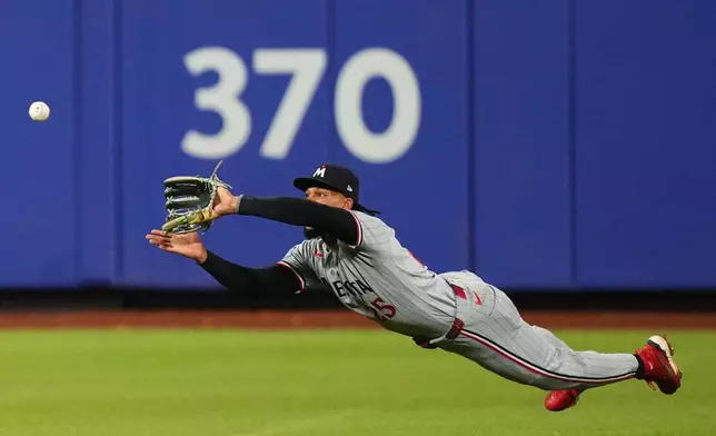 Minnesota Twins' Byron Buxton dives to catch a ball hit by New York Mets' Marcus Semien for an out to end the eighth inning of a baseball game Wednesday, April 22, 2026, in New York. (AP Photo/Frank Franklin II)