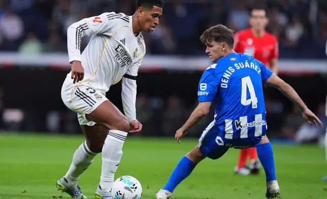 Real Madrid's Jude Bellingham passes Alaves' Denis Suarez during a La Liga soccer match between Real Madrid and Alaves in Madrid, Spain, Tuesday, April 21, 2026. (AP Photo/Manu Fernandez)