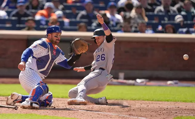 Colorado Rockies' Brett Sullivan (26), right, slides safely home while New York Mets catcher Luis Torrens waits for the ball during the seventh inning of the first baseball game of a doubleheader, Sunday, April 26, 2026, in New York. (AP Photo/Seth Wenig)
