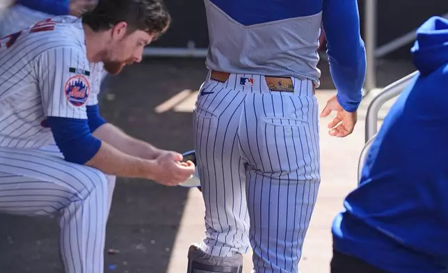 New York Mets Francisco Lindor walks in the dugout wearing a protective boot during the sixth inning of the first baseball game of a doubleheader against the Colorado Rockies, Sunday, April 26, 2026, in New York. (AP Photo/Seth Wenig)