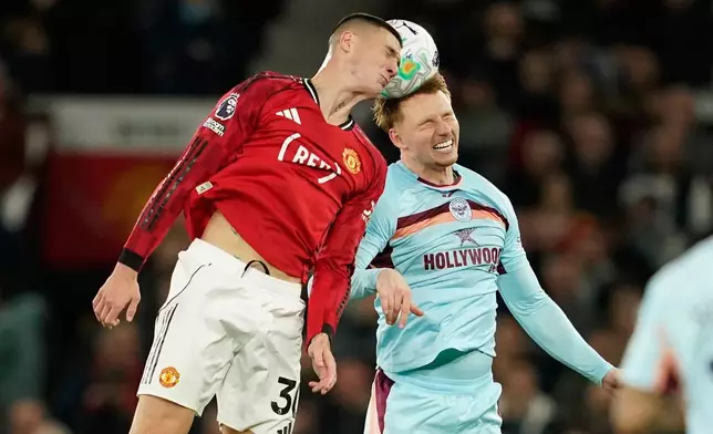 Manchester United's Benjamin Sesko, left, and Brentford's Sepp van den Berg jump for the ball during the Premier League soccer match between Manchester United and Brentford in Manchester, England, Monday, April 27, 2026. (AP Photo/Dave Thompson)