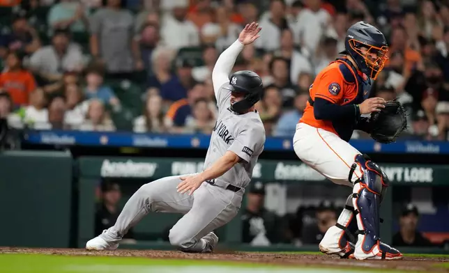 New York Yankees' Randal Grichuk scores a run on Jazz Chisholm Jr.'s RBI single during the seventh inning of a baseball game against the Houston Astros, Friday, April 24, 2026, in Houston. (AP Photo/ Karen Warren)