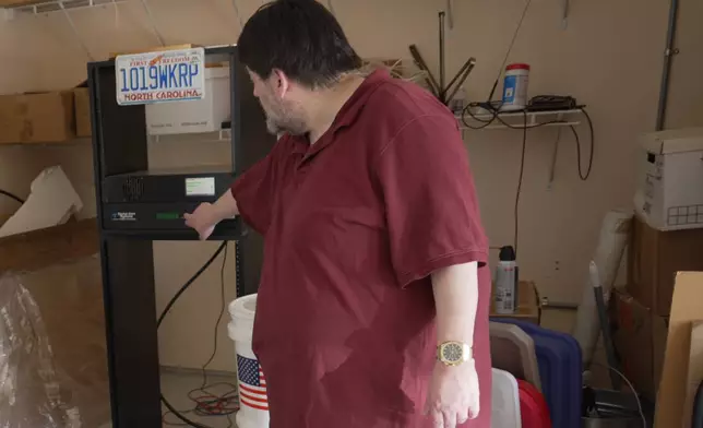 D.P. McIntire points to the transmitter for WKRP radio in a corner of his garage in Raleigh, N.C., on Thursday, April 2, 2026. (AP Photo/Allen G. Breed)