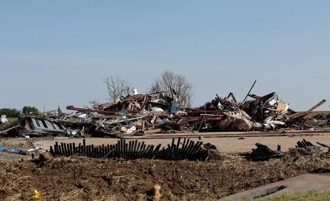 A commercial shop left in a pile of debris Friday, April 24, 2026, in a neighborhood that was damaged by a tornado Thursday in Enid, Okla. (AP Photo/Alonzo Adams)