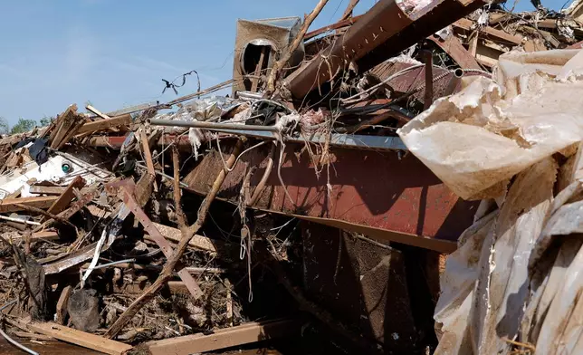 Bent steel beams and debris from a commercial shop is shown Friday, April 24, 2026, in Enid, Okla. (AP Photo/Alonzo Adams)