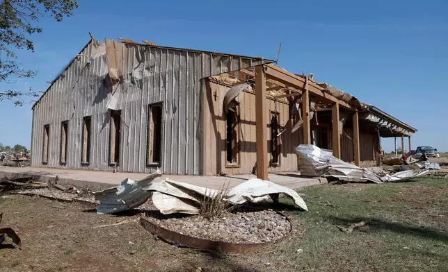 A commercial business shop in a neighborhood that was damaged by a tornado on Thursday is shown on Friday, April 24, 2026, in Enid, Okla. (AP Photo/Alonzo Adams)