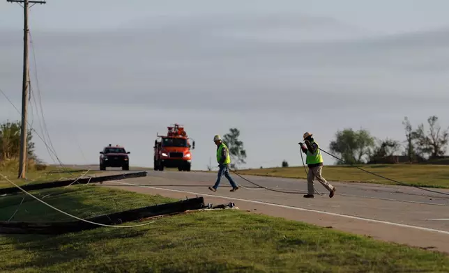 Electric crews remove down power lines in Enid, Okla., Friday, April 24, 2026, in the aftermath of a tornado that barreled through Oklahoma Thursday. (AP Photo/Alonzo Adams)