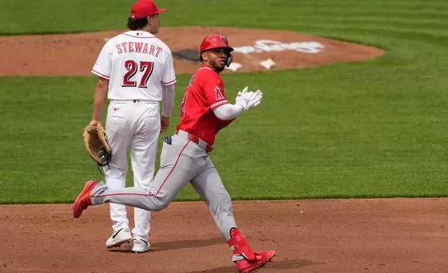 Los Angeles Angels' Oswald Peraza claps as he rounds the bases past Cincinnati Reds first baseman Sal Stewart (27) after hitting a solo home run in the fourth inning of a baseball game in Cincinnati, Sunday, April 12, 2026. (AP Photo/Carolyn Kaster)