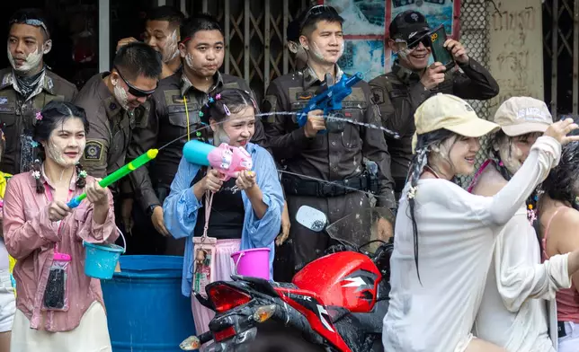 Thai policemen and peoples participate in the Songkran water festival to celebrate the Thai New Year in Prachinburi province, Thailand, Monday, April 13, 2026. (AP Photo/Wason Wanichakorn)