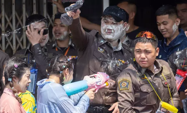 Thai policemen participate in the Songkran water festival to celebrate the Thai New Year in Prachinburi province, Thailand, Monday, April 13, 2026. (AP Photo/Wason Wanichakorn)