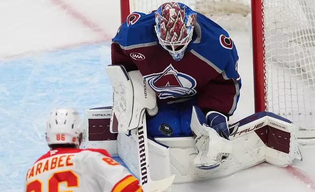 Calgary Flames left wing Joel Farabee, front, puts a shot on Colorado Avalanche goaltender MacKenzie Blackwood in the first period of an NHL hockey game Thursday, April 9, 2026, in Denver. (AP Photo/David Zalubowski)