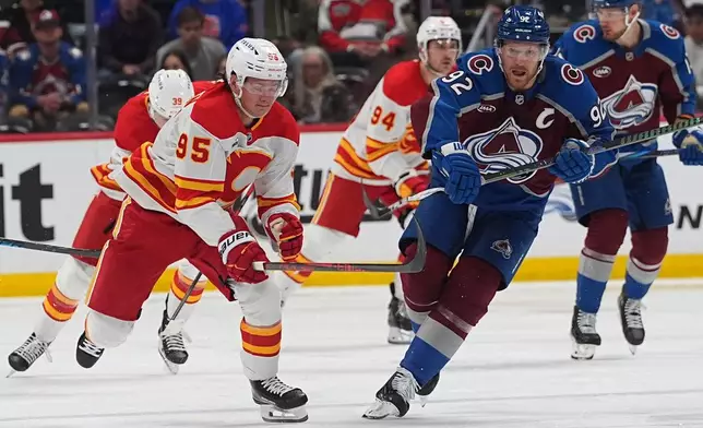 Calgary Flames left wing Victor Olofsson, front left, pursues the puck with Colorado Avalanche left wing Gabriel Landeskog (92) in the second period of an NHL hockey game Thursday, April 9, 2026, in Denver. (AP Photo/David Zalubowski)