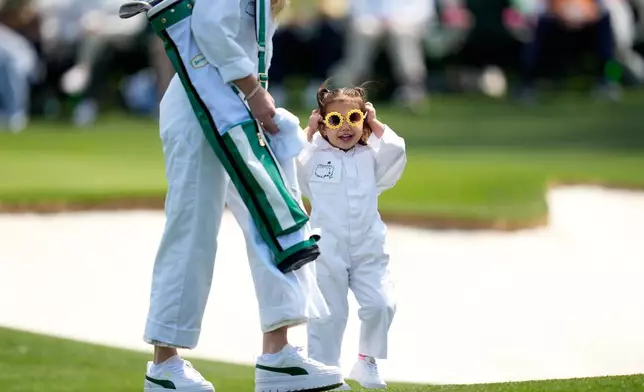 J.J. Spaun's daughter, Violet Windsor, puts on sunglasses on the first hole during par-3 contest ahead of the Masters golf tournament at the Augusta National Golf Club, Wednesday, April 8, 2026, in Augusta, Ga. (AP Photo/Ashley Landis)
