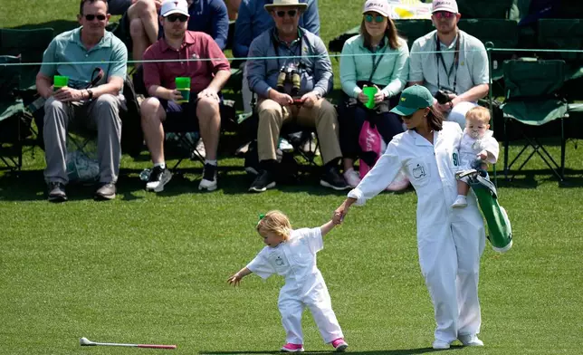 Jordan Spieth's daughter, Sophie, left, reaches for her club as mom Annie Verret holds son Sully, on the third hole during par-3 contest ahead of the Masters golf tournament at the Augusta National Golf Club, Wednesday, April 8, 2026, in Augusta, Ga.(AP Photo/Eric Gay)