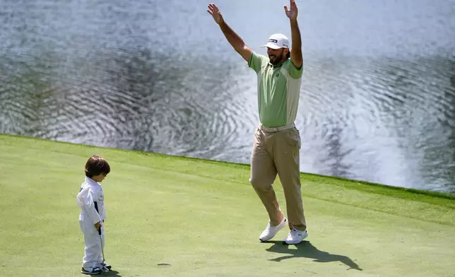 Max Homa, right, celebrates a putt by his son, Cam Andrew, on the eighth hole during par-3 contest ahead of the Masters golf tournament at the Augusta National Golf Club, Wednesday, April 8, 2026, in Augusta, Ga. (AP Photo/Gerald Herbert)