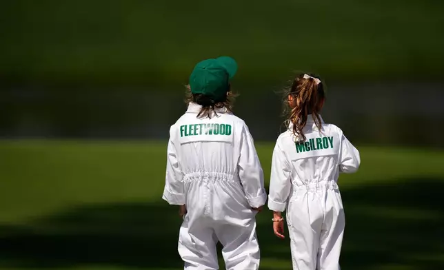 Tommy Fleetwood' son, Franklin, left, and Rory McIlroy's daughter, Poppy, stand together during par-3 contest ahead of the Masters golf tournament at the Augusta National Golf Club, Wednesday, April 8, 2026, in Augusta, Ga. (AP Photo/Eric Gay)