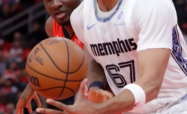 Houston Rockets center Clint Capela, left, knocks the ball away from Memphis Grizzlies forward Taj Gibson (67) during the first half of an NBA basketball game Sunday, April 12, 2026, in Houston. (AP Photo/Michael Wyke)