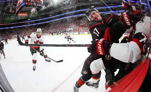 Carolina Hurricanes' Andrei Svechnikov (37) checks Ottawa Senators' Thomas Chabot (72) into the boards during the second period of Game 2 of an NHL hockey Stanley Cup first-round playoff series in Raleigh, N.C., Monday, April 20, 2026. (AP Photo/Karl DeBlaker)