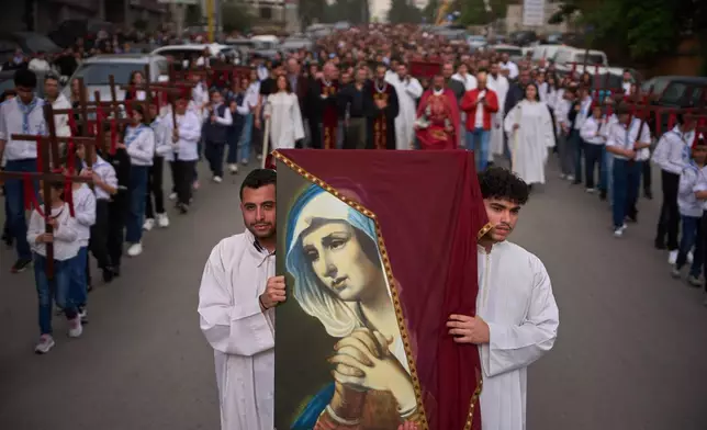 Parishioners walk in a procession after a Good Friday Mass at St. Anthony Church, which was devoted to expressing solidarity with Christian villagers in southern Lebanon displaced by the war in Jdeideh, a suburb of Beirut, Lebanon, Friday, April 3, 2026. (AP Photo/Emilio Morenatti)