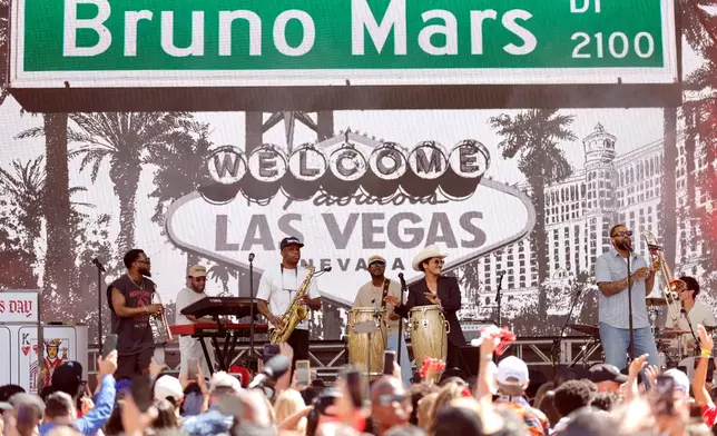 Bruno Mars, wearing cowboy hat, and his band The Hooligans perform for fans in Toshiba Plaza after a parade down the Las Vegas Strip Friday, April 10, 2026, in Las Vegas, on "Bruno Mars Day." (Steve Marcus/Las Vegas Sun via AP)