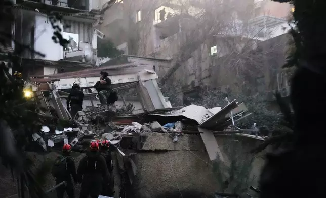 Israeli security forces and rescue teams work amid the rubble of a residential building struck by an Iranian missile in Haifa, Israel, Sunday, April 5, 2026. (AP Photo/Ariel Schalit)