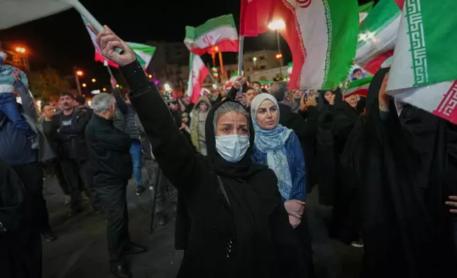 Women hold Iranian flags during a pro-government gathering in a square in Tehran, Iran, Sunday, April 5, 2026. (AP Photo/Francisco Seco)