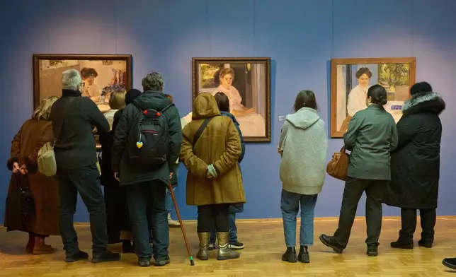 Visitors at Ukraine's National Art Museum bundle up due power outages caused by Russian air attacks on the country's energy system during winter in Kyiv, Ukraine, Friday, Feb. 6, 2026. (AP Photo/Efrem Lukatsky)