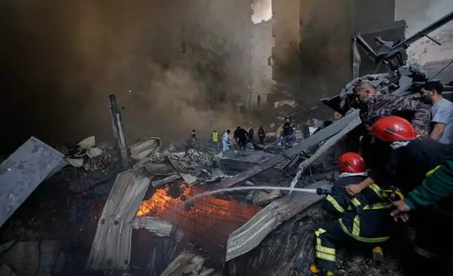 Firefighters try to put out flames at the site of an Israeli airstrike that struck an apartment building in Beirut, Lebanon, Wednesday, April 8, 2026. (AP Photo/Bilal Hussein)