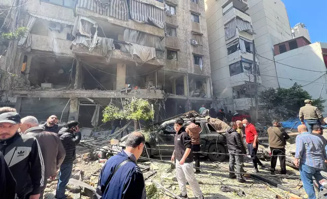 People gather at the site of an Israeli airstrike that hit an apartment building in Beirut, Lebanon, Wednesday, April 8, 2026. (AP Photo/Hussein Malla)
