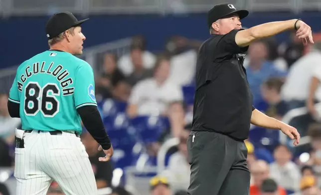 Miami Marlins manager Clayton McCullough (86) is ejected by first base umpire Cory Blaser, right, during the first inning of a baseball game against the Milwaukee Brewers, Sunday, April 19, 2026, in Miami. (AP Photo/Lynne Sladky)