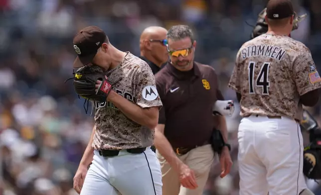 San Diego Padres pitcher Nick Pivetta, left, reacts as he exits during the fourth inning of a baseball game against the Colorado Rockies Sunday, April 12, 2026, in San Diego. (AP Photo/Gregory Bull)
