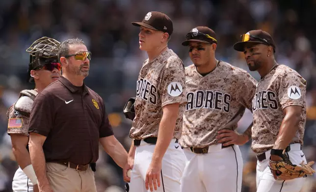 San Diego Padres pitcher Nick Pivetta, center, reacts before exiting during the fourth inning of a baseball game against the Colorado Rockies Sunday, April 12, 2026, in San Diego. (AP Photo/Gregory Bull)