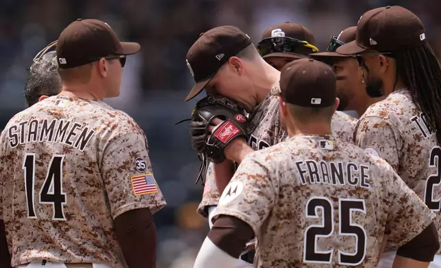 San Diego Padres pitcher Nick Pivetta, center, reacts before exiting during the fourth inning of a baseball game against the Colorado Rockies Sunday, April 12, 2026, in San Diego. (AP Photo/Gregory Bull)