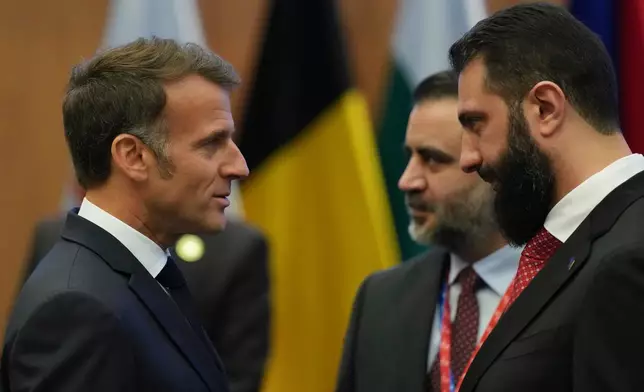 French President Emmanuel Macron, left, talks with the Syrian President Ahmad al-Sharaa during the EU Summit in Nicosia, Cyprus, Friday, April 24, 2026. (AP Photo/Petros Karadjias)