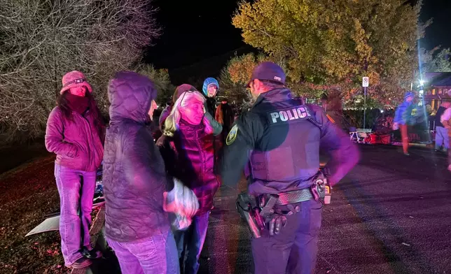 Franci Stagi center, speaks with a Durango, Colo., Police Department officer early Oct. 29, 2025, after an immigration officer allegedly assaulted her in Durango, Colo. (Scout Edmondson/Durango Herald via AP)
