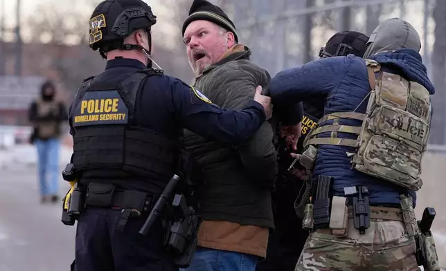 FILE - Law enforcement detain a man outside the Bishop Henry Whipple Federal Building during a protest, Jan. 17, 2026, in Minneapolis. (AP Photo/Yuki Iwamura, File)