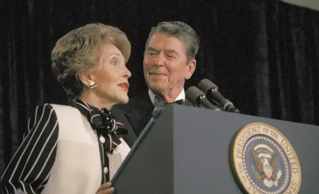 FILE - President Ronald Reagan watches as first lady Nancy Reagan comments from the podium during the White House Correspondents' Association annual dinner on April 23, 1987, in Washington. (AP Photo/Charles Tasnadi, File)