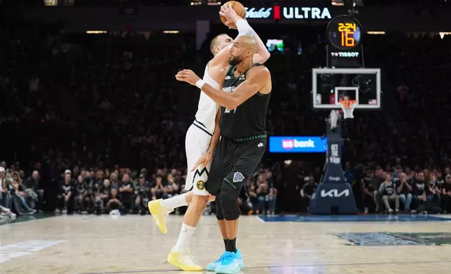 Denver Nuggets center Nikola Jokic (15), back, is fouled by Minnesota Timberwolves center Rudy Gobert (27) during the first half in Game 3 of a first-round NBA basketball playoff series, Thursday, April 23, 2026, in Minneapolis. (AP Photo/Abbie Parr)