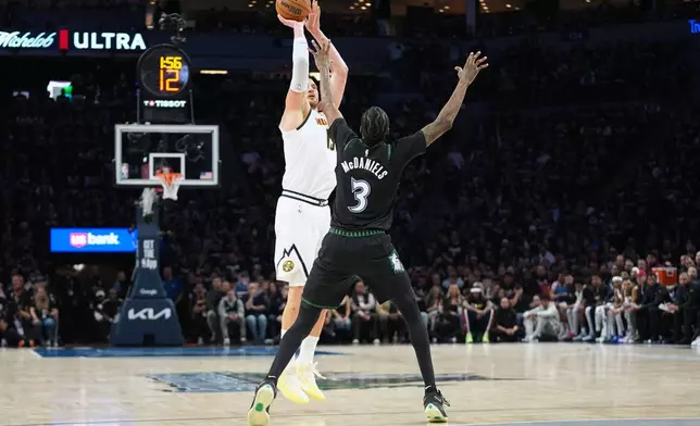 Denver Nuggets center Nikola Jokic (15) shoots over Minnesota Timberwolves forward Jaden McDaniels (3) during the first half in Game 3 of a first-round NBA basketball playoff series, Thursday, April 23, 2026, in Minneapolis. (AP Photo/Abbie Parr)