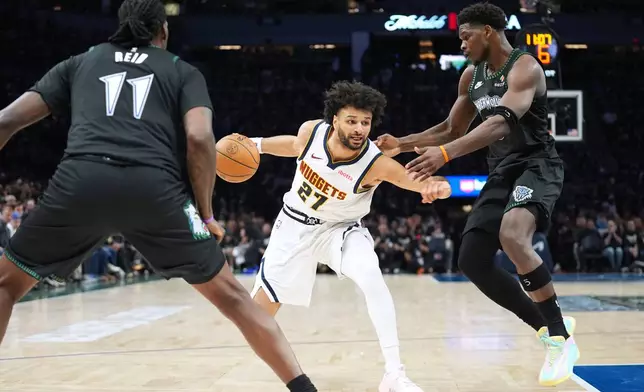 Denver Nuggets guard Jamal Murray (27) works toward the basket as Minnesota Timberwolves center Naz Reid (11) and guard Anthony Edwards (5) defend during the first half in Game 3 of a first-round NBA basketball playoff series, Thursday, April 23, 2026, in Minneapolis. (AP Photo/Abbie Parr)